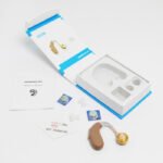 AXON hearing aid unboxing with accessories including batteries, earplugs, and operation manual in Pakistan.