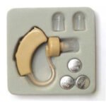 WT Hearing Aid spare accessories tray with two ear tips and three silver batteries.