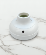 Minimalist white design of bulb holder hidden camera on marble surface.